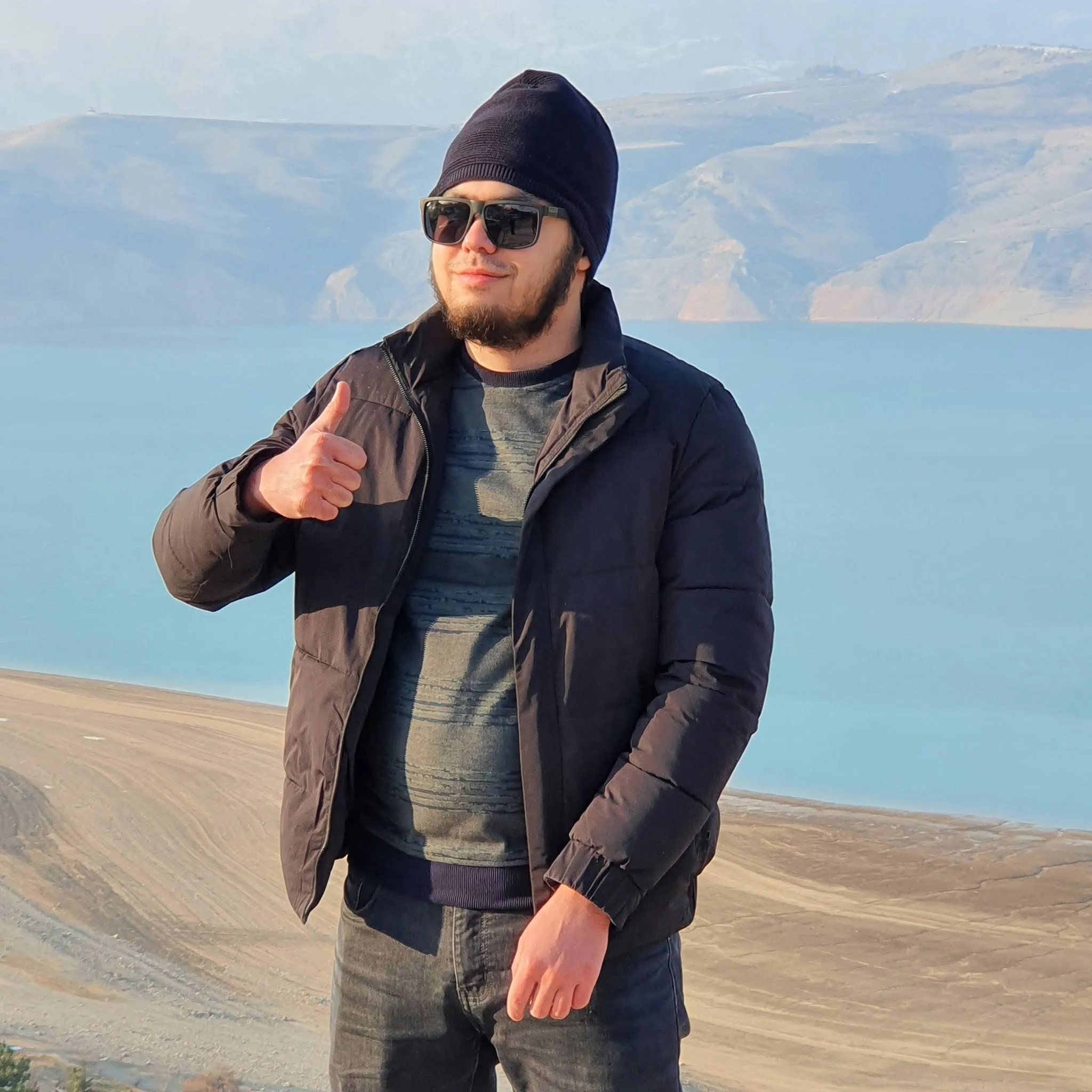 me standing by a lake with mountains behind